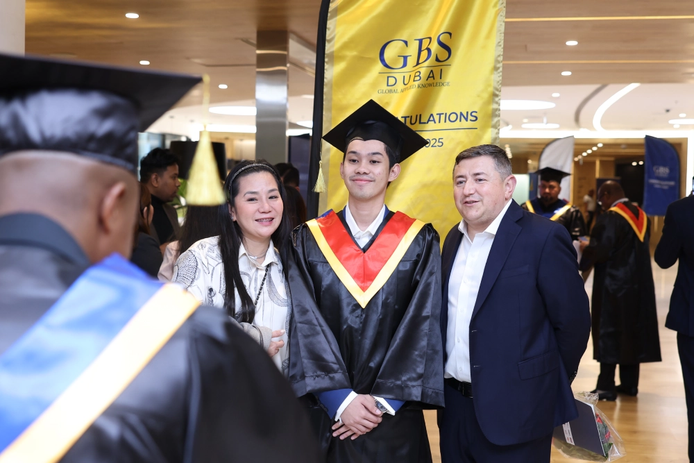 A graduate posing for a photograph with guests