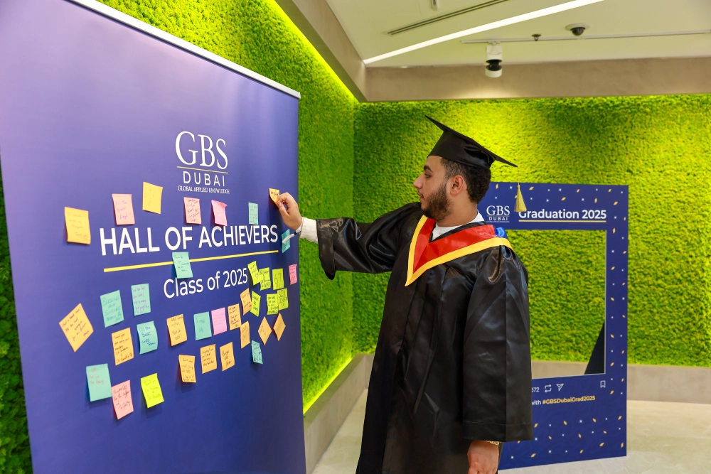 A graduate at the Hall of Achievers display